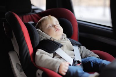 Portrait of toddler boy sleeping in car seat